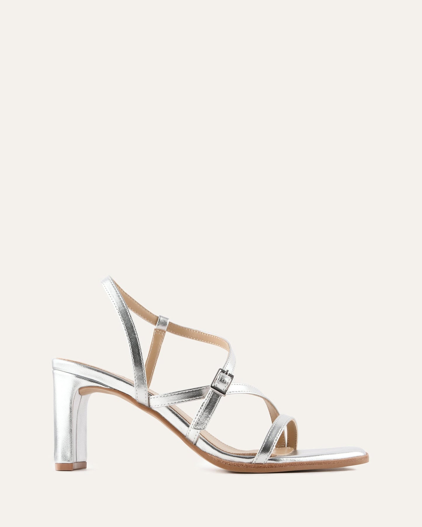 Silver high-heeled sandal on a light beige background