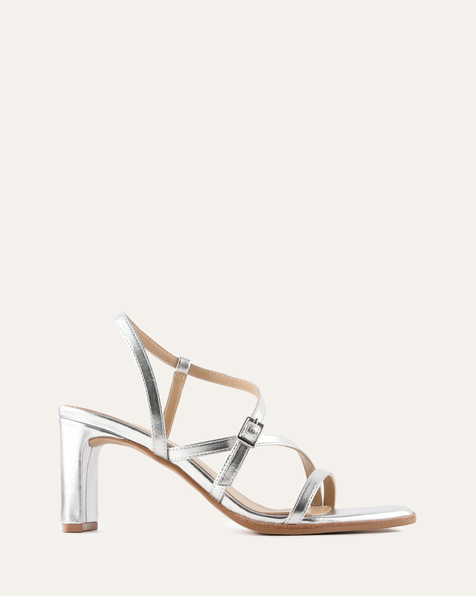 Silver high-heeled sandal on a light beige background